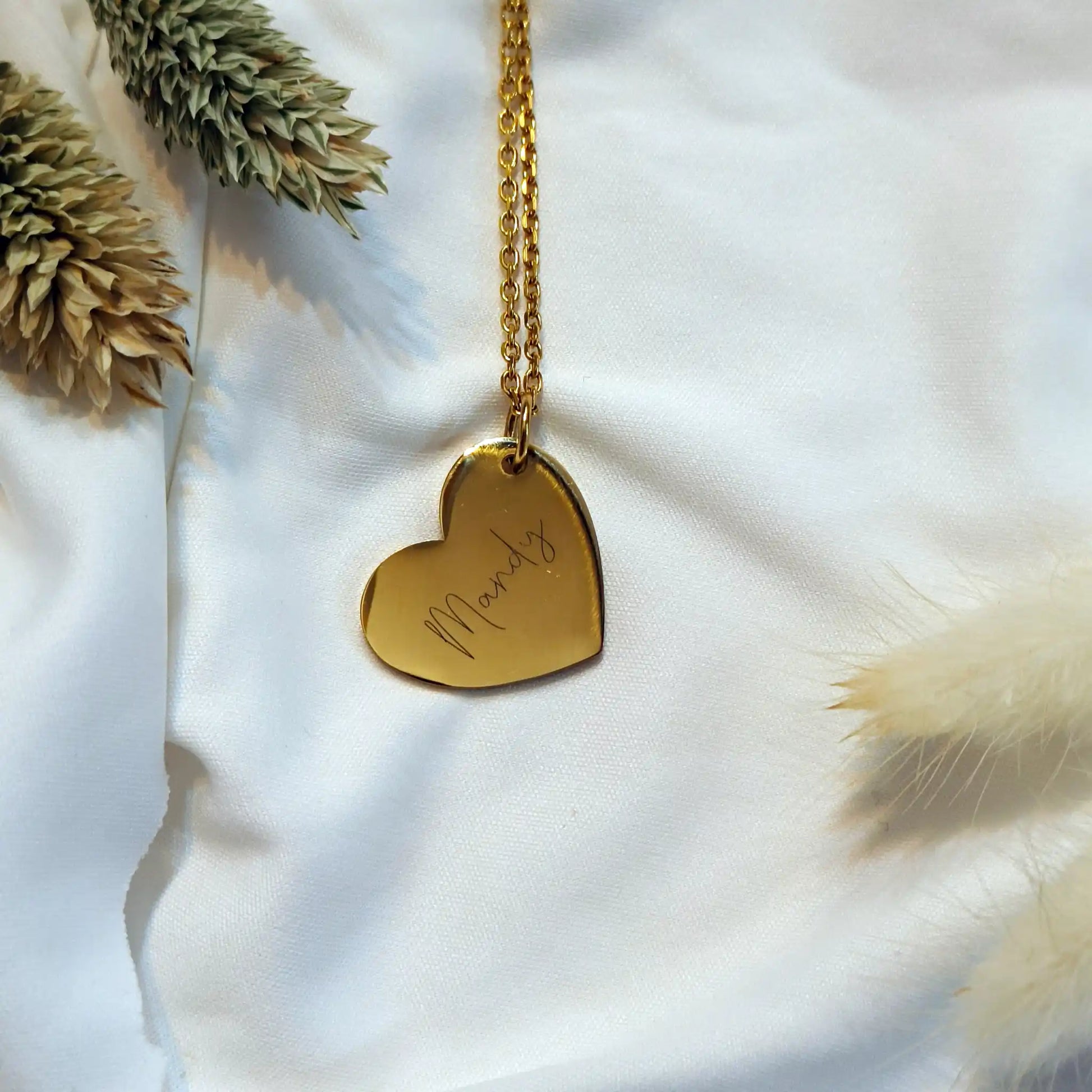 Gouden ketting met een bedel in de vorm van een hart, met gegraveerde naam